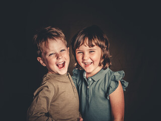 preciosos hermanos mellizos rubios divirtiendose en una sesion de fotos de estudio