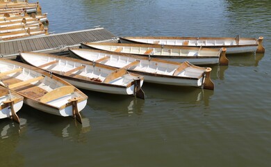 A line of white wooden rowing boats on the River Avon at Stratford-upon-Avon, Warwickshire, England, UK.