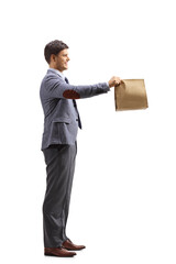 Full length profile shot of a man holding a food paper bag