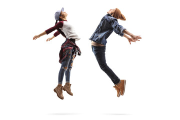 Full length profile shot of a young man and woman performing a dance jump