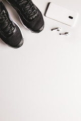 Mockup mobile cellphone with earphone and running shoes on white background. Healthy lifestyles