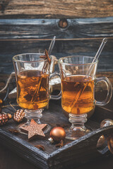 Two glasses with tea on a christmas decorated wooden tray. Vertical stock photo.