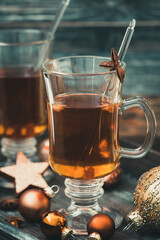 Glass with tea on a christmas decorated wooden tray. Vertical stock photo.