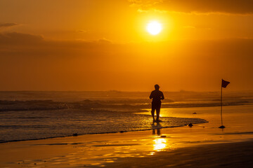 Fototapeta na wymiar Tropical sunsets in Bali with surfer