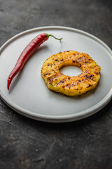 Grilled pineapple slices on plate. Grilled pineapple with chilli