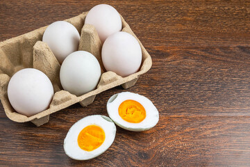 White duck eggs and salted egg food on a wooden table