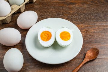 White duck eggs and salted egg food on a wooden table
