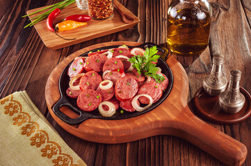 Sliced smoked calabrese sausage with onion in a wooden background - Brazilian appetizer