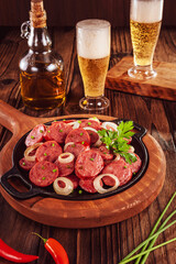 Sliced smoked fried calabrese sausage with onion and beer - Brazilian appetizer