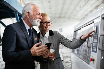 Man and woman discussing work. Colleagues working in factory...