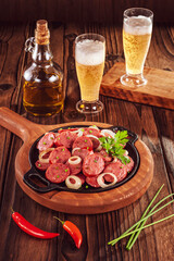Sliced smoked fried calabrese sausage with onion and beer - Brazilian appetizer