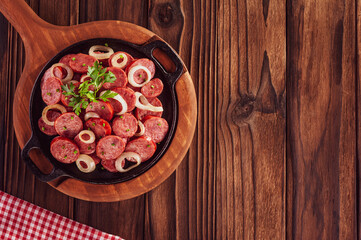Sliced smoked fried calabrese sausage with onion - Brazilian appetizer top view with space copy