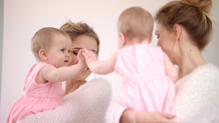 Mother with baby looking mirror. Sweet child playing with mirror