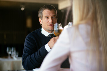 Handsome businessman dressed in the suit drinking wine. Businessman enjoying in the restaurant..