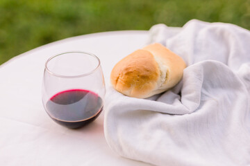 Horizontal shot of red wine and a loaf of bread in a Christian service 