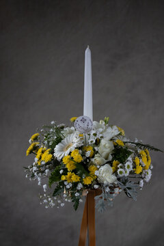 First Holy Communion Flower Bouquets. White Candle Decorated With White,and Yellow Flowers. Grey Backgroud