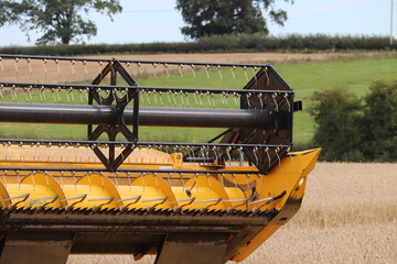 Farm machinery combine harvester working on farm land summer 2020