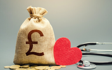 British pound sterling money bag and stethoscope. Health life insurance financing concept....