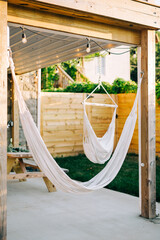 Hammock Swings hung up in a backyard with wood fences. 