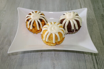 Three mini muffin cakes with frosting.