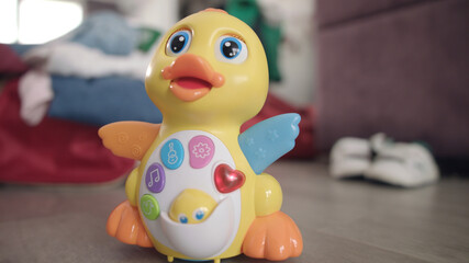 Baby toy duck moving on floor. Musical toy with button and lights moving
