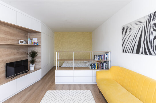 White modern minimalistic living room with yellow sofa conected with bedroom