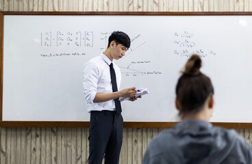 Asian teacher is teaching students in the classroom.