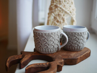 two white knitted mugs, insulation for mugs