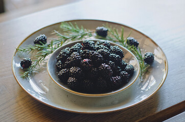 Blackberry berries on a white plate. Flat lay. Top view. 