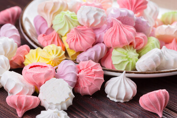 Colorful sweet meringue cookies assortment on wooden table