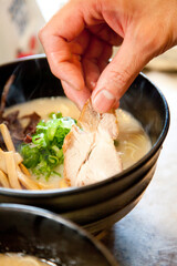 ラーメンを盛り付ける手元