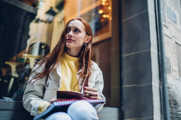 Pretty student sitting near cafe