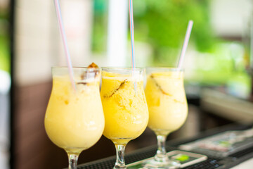 Close up photo of tasty milky cocktails on bar near pool in a su