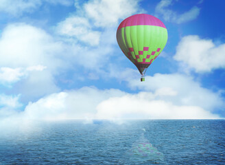 Dream world. Hot air balloon in blue sky with clouds over sea