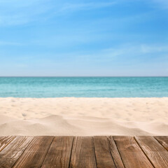 Fototapeta na wymiar Wooden surface on sandy beach near ocean