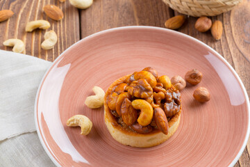 Tart with nuts on pink plate close up