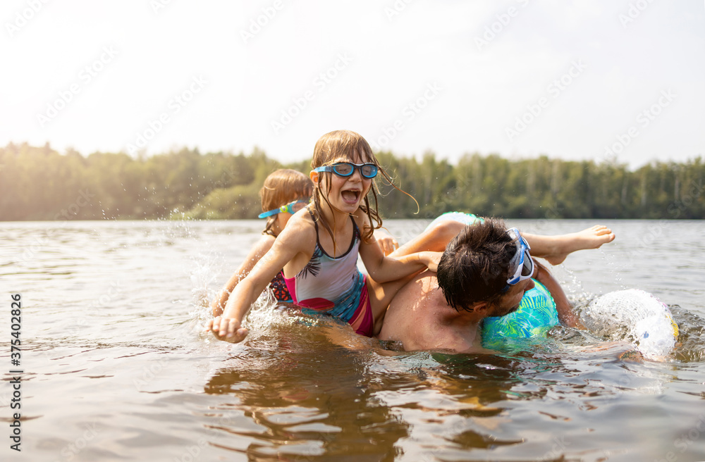 Wall mural father and kids having fun in the lake