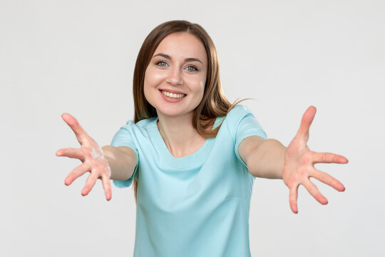 Free hugs. Welcoming gesture. Cheerful woman in blue with open hands smiling isolated on light copy space background. Come here. Nice to meet you.