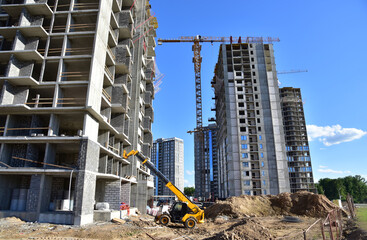 Telescopic handler work at the construction site. Construction machinery for loading. Tower crane...