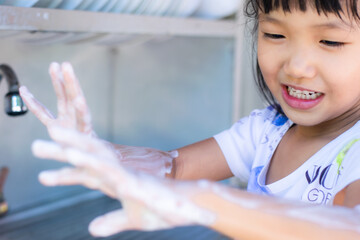 An ASEAN girl aged 3 - 4 is washing his hands.