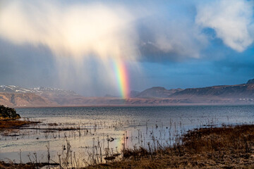 View from the southern ring road, Iceland on a stormy day with dramatic clouds, mountains and a rainbow
