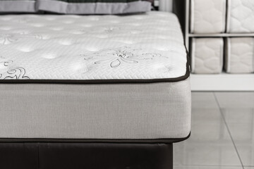 Choosing mattress. Close-up white mattress in furniture store. Copy space