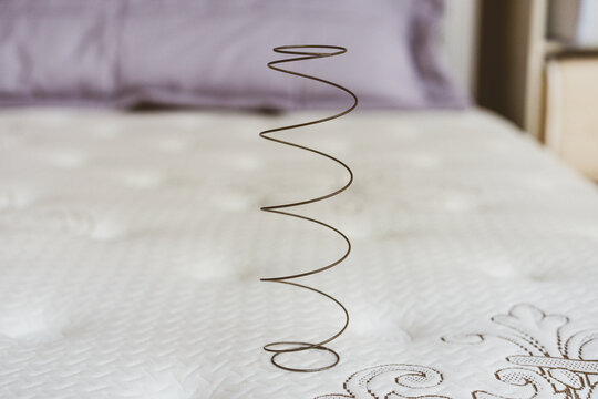 Metal spring on a white mattress. The concept of filling a mattress. 
