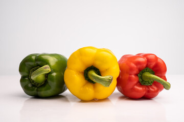 colorful bell peppers arranged in a row with white background