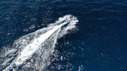Obraz premium Aerial photo of woman operating jet ski cruising in low speed in deep blue crystal clear waters