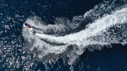 Naklejka premium Aerial photo of woman operating jet ski cruising in low speed in deep blue crystal clear waters