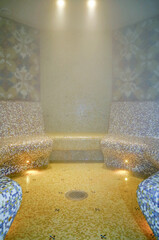 Turkish bath or steam sauna with mosaic tiles inside male locker room of spa or wellness are...