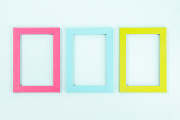 Creative layout made of three bright colored frames on blue background. Flat lay Top view Copy...