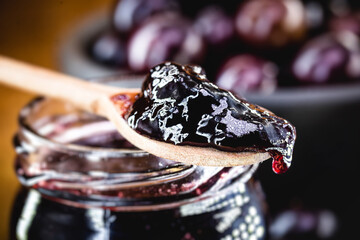 jabuticaba (or jaboticaba) jelly, close-up on wooden spoon, grape from latin america used in sweets and drinks typical of brazilian cuisine.