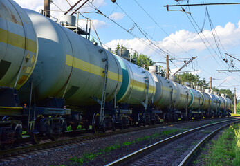 Fototapeta na wymiar Transport tank car LNG by rail, gas - oil products. LPG transport propane. The fuel train, rolling stock with petrochemical tank cars. Liquefied natural gas export. Object in Motion, Out of focus